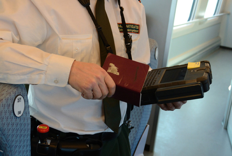 Suomalainen rajavartija skannaa passin tietoja laitteellaan.
